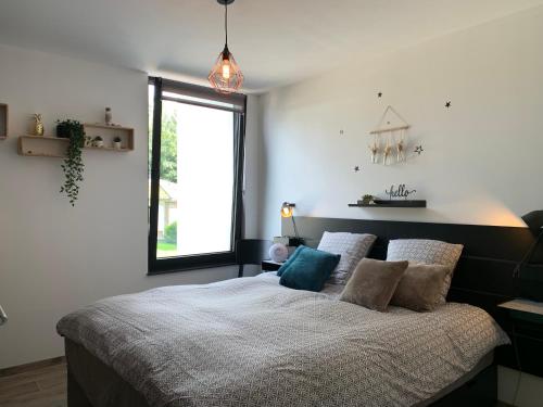 a bedroom with a bed with pillows and a window at Chez Isa in Faymonville