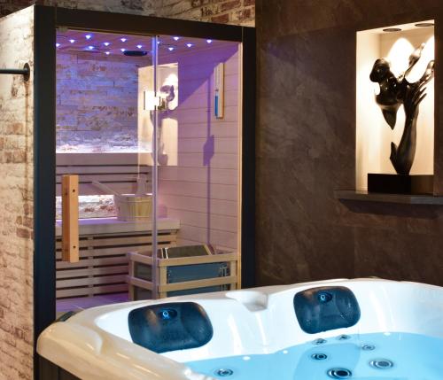 uma casa de banho com uma banheira e um lavatório em La Forge By CV - Jacuzzi, Sauna, plat repas et petit déjeuner em Eppe-Sauvage