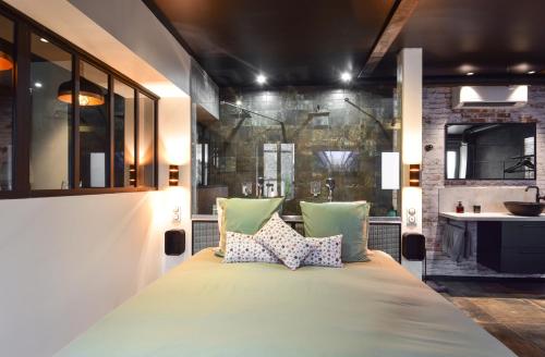 um quarto com uma cama grande e 2 almofadas em La Forge By CV - Jacuzzi, Sauna, plat repas et petit déjeuner em Eppe-Sauvage