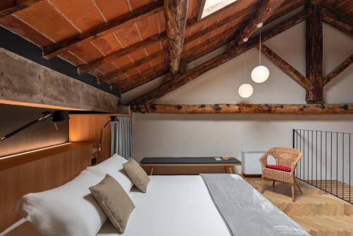 ein Schlafzimmer mit einem weißen Bett und einem Stuhl in der Unterkunft Rambaldi Apartments Casa nr 7 in Bardolino