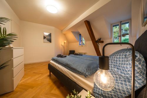 a bedroom with a bed with a blue comforter at Old town apt in the heart of Thun with garden in Thun