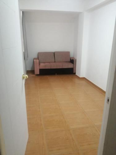 ein Sofa in einem Zimmer mit Holzboden in der Unterkunft Barrio Particular in Talara
