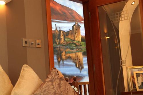a painting of a castle on the wall of a bedroom at Ayrs and Graces - Luxury Bed and Breakfast in Ayr