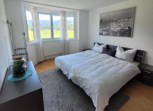 um quarto com uma grande cama branca e uma mesa em Haus Castellblick em Ballrechten