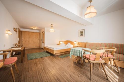 a room with a bed and a table and chairs at Batzenhäusl in Seefeld in Tirol