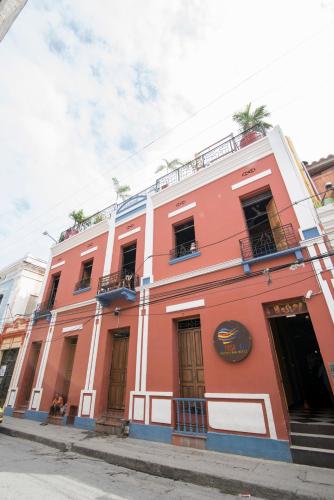 a red building on the side of a street at La Brisa Loca Hostel in Santa Marta