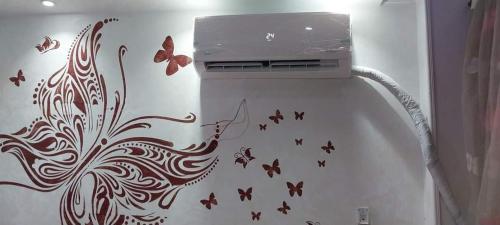 - un réfrigérateur blanc avec des papillons sur le mur dans l'établissement احمد عصمت عين شمس, au Caire