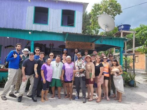 een groep mensen die poseren voor een foto voor een gebouw bij CANTO DOS PASSAROS in Manaus