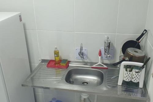 a kitchen counter with a stainless steel sink at Apartamento no Condomínio Roma com estacionamento in Pôrto Santana