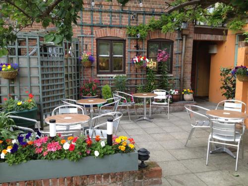 a patio with tables and chairs and flowers at Samuel Pepys in Harwich