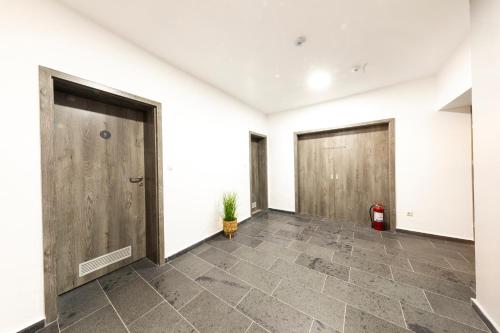 a hallway with three doors and a potted plant at Filo Hotel Wellness & Spa in Gheorgheni