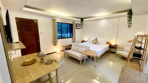 a bedroom with a bed and a table and chairs at Namal Apartelle - Free Scooter & Concierge Service in El Nido