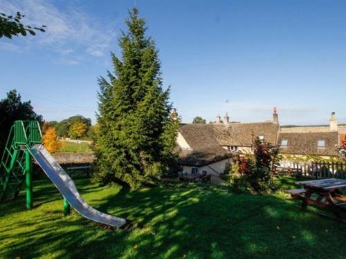 un parque infantil con un tobogán en un patio en White Hart Ufford- Stamford en Ufford