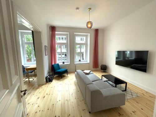 a living room with a couch and a flat screen tv at Park Lane Business-Apartment in Hamburg