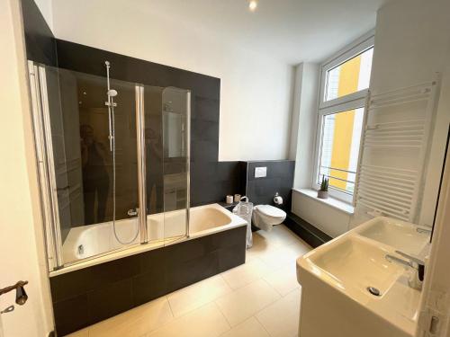 a bathroom with a tub and a toilet and a sink at Park Lane Business-Apartment in Hamburg