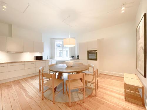 una cucina e una sala da pranzo con tavolo e sedie in legno di Large & Modern 4 Bedroom Flat a Copenaghen