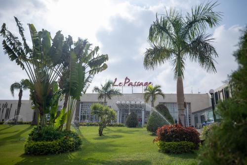 a hotel with palm trees in front of a building at Le Passage Cairo Hotel & Casino in Cairo