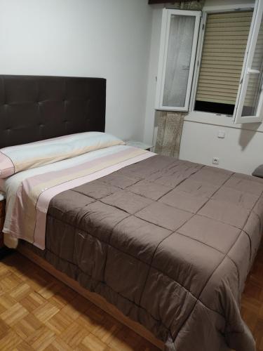 un grande letto in una camera da letto con finestra di Apartamento Abrantes a Madrid