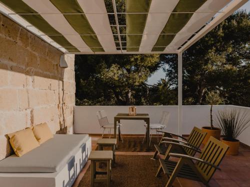 a patio with a couch and a table and chairs at Amagatay Luxury Boutique Hotel - Adults Only in Alaior