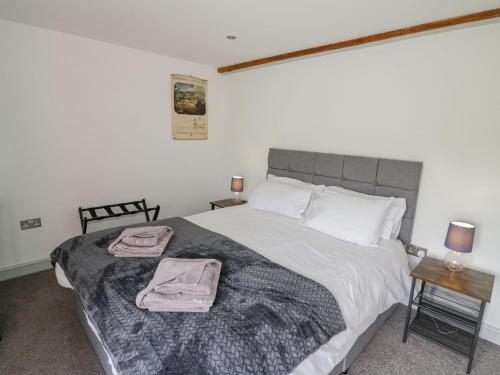 a bedroom with a large bed with two towels on it at Plough Share in Gloucester