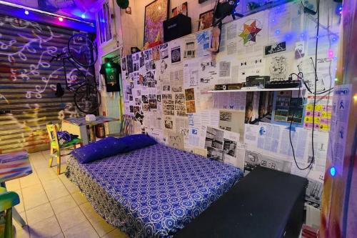 um quarto com uma cama roxa e uma parede com cartazes em Um Bar para chamar de SEU! em São Paulo