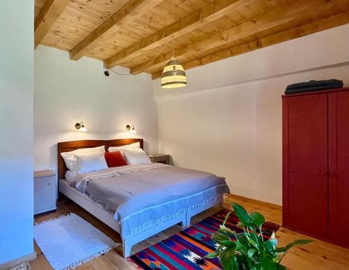 a bedroom with a bed and a red dresser at ZebRegény Vendégház in Zebegény
