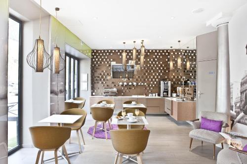 a restaurant with tables and chairs and a kitchen at Hotel Eiffel Segur in Paris