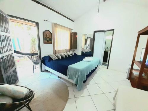 1 dormitorio con cama azul y espejo en Arraial Casinha Centro en Arraial d'Ajuda