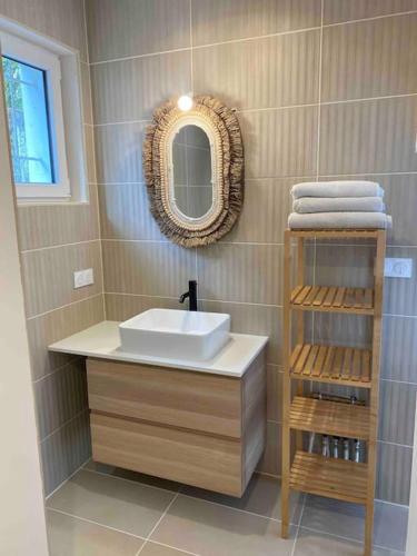 une salle de bain avec un lavabo, un miroir et des serviettes dans l'établissement Jolie Maison à 5mins des plages et du lac, à Soorts-Hossegor