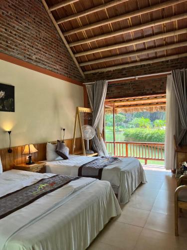a bedroom with two beds and a balcony at Tam Coc Nature in Ninh Binh