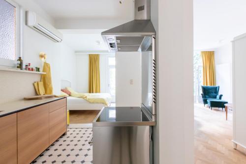 a kitchen with a refrigerator and a living room at Pauline Loveling apartment with quiet garden and 2 bathrooms in Antwerp