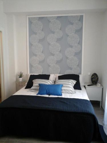 a bedroom with a large bed with two blue pillows at Alojamiento EntreHoces in Cuenca