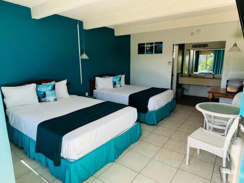 um quarto de hotel com duas camas e uma cadeira em Big Pine Key Motel em Big Pine Key