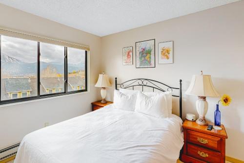 1 dormitorio con cama blanca y ventana en Shimmering Summit Hideaway, en Mount Crested Butte