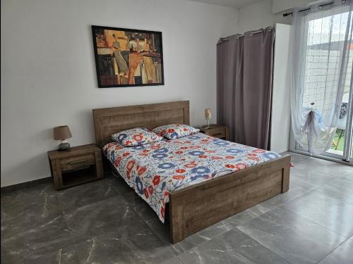 a bedroom with a bed with a comforter and pillows at Un petit coin de paradis à La Réunion in Saint-Joseph