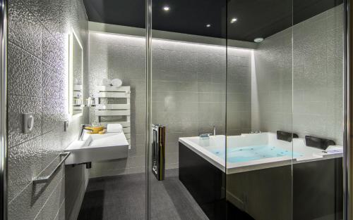 uma casa de banho com uma banheira, um lavatório e um chuveiro em A coté de la place du pilori em Angers