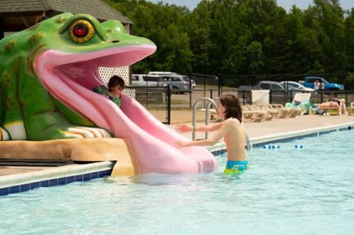 chłopiec i dziewczynka bawiący się na zjeżdżalni wodnej w basenie w obiekcie Wilderness Presidential Resort w mieście Spotsylvania
