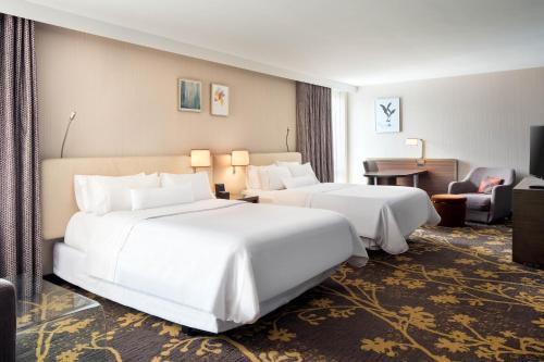 a hotel room with two beds and a desk at The Westin Cleveland Downtown in Cleveland