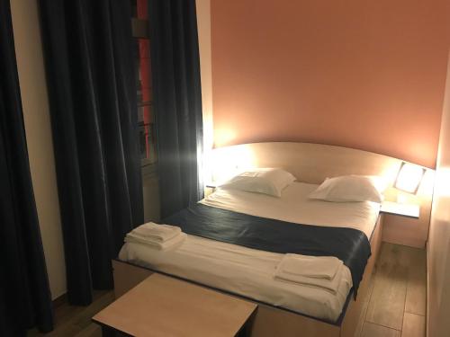 a small bed in a room with two lamps at Hotel César Centre-ville Gare Charleville-Mézières in Charleville-Mézières