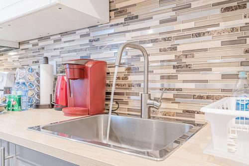 a kitchen with a sink and a red appliance at Executive Apartment - 2BDR Parking Self-check in - Walkout basement Lower Unit in Mississauga