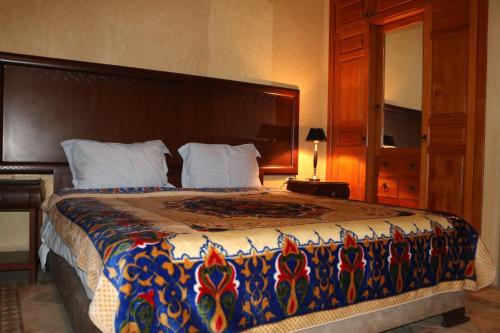 - une chambre avec un grand lit et un couvre-lit coloré dans l'établissement nakhil villa palm, à Marrakech