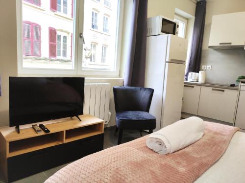 a bedroom with a bed and a tv and a chair at Le LUX 11 in Thionville