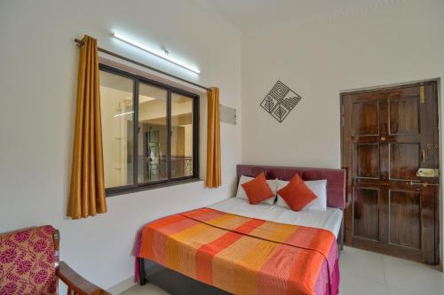 a bedroom with a bed and a window at Amazing Pool View Candolim Goa 1BHK Apartment in Candolim
