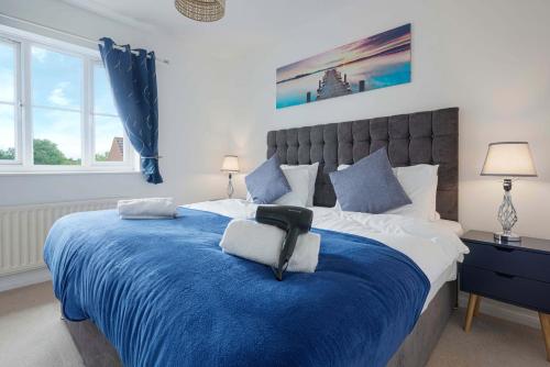 a bedroom with a blue and white bed with two lamps at Wonderful 2 bed accommodates 6 in Shenley Brook End
