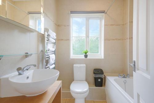 a bathroom with a toilet and a sink and a tub at Wonderful 2 bed accommodates 6 in Shenley Brook End