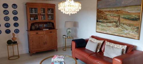 una sala de estar con un sofá rojo y una pintura en Landhof Osterdeich, en Emmelsbüll-Horsbüll