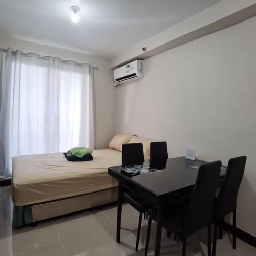 una camera con letto e tavolo con sedie di Affordable Condo w/ Wi-Fi, Pool & Shower Heater a Lapu Lapu City