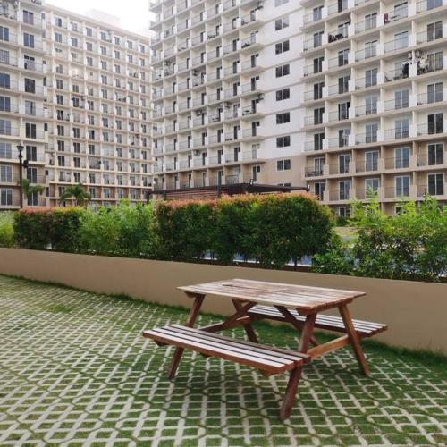 a picnic table and a bench in front of buildings at Affordable Condo w/ Wi-Fi, Pool & Shower Heater in Lapu Lapu City