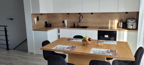 a kitchen with a wooden table with a bowl of fruit on it at Leszka Loft Apartment in Wodzisław Śląski