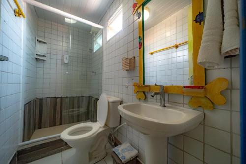 a bathroom with a toilet and a sink at Pousada das Galinhas in Porto De Galinhas